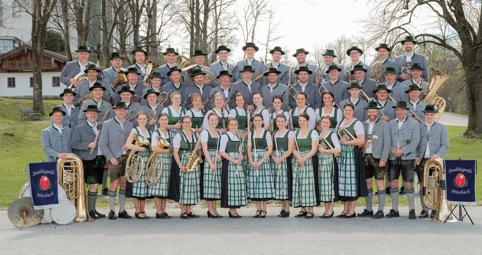 Ein Gruppenfoto, auf dem eine Stadtkapelle in traditioneller Kleidung.