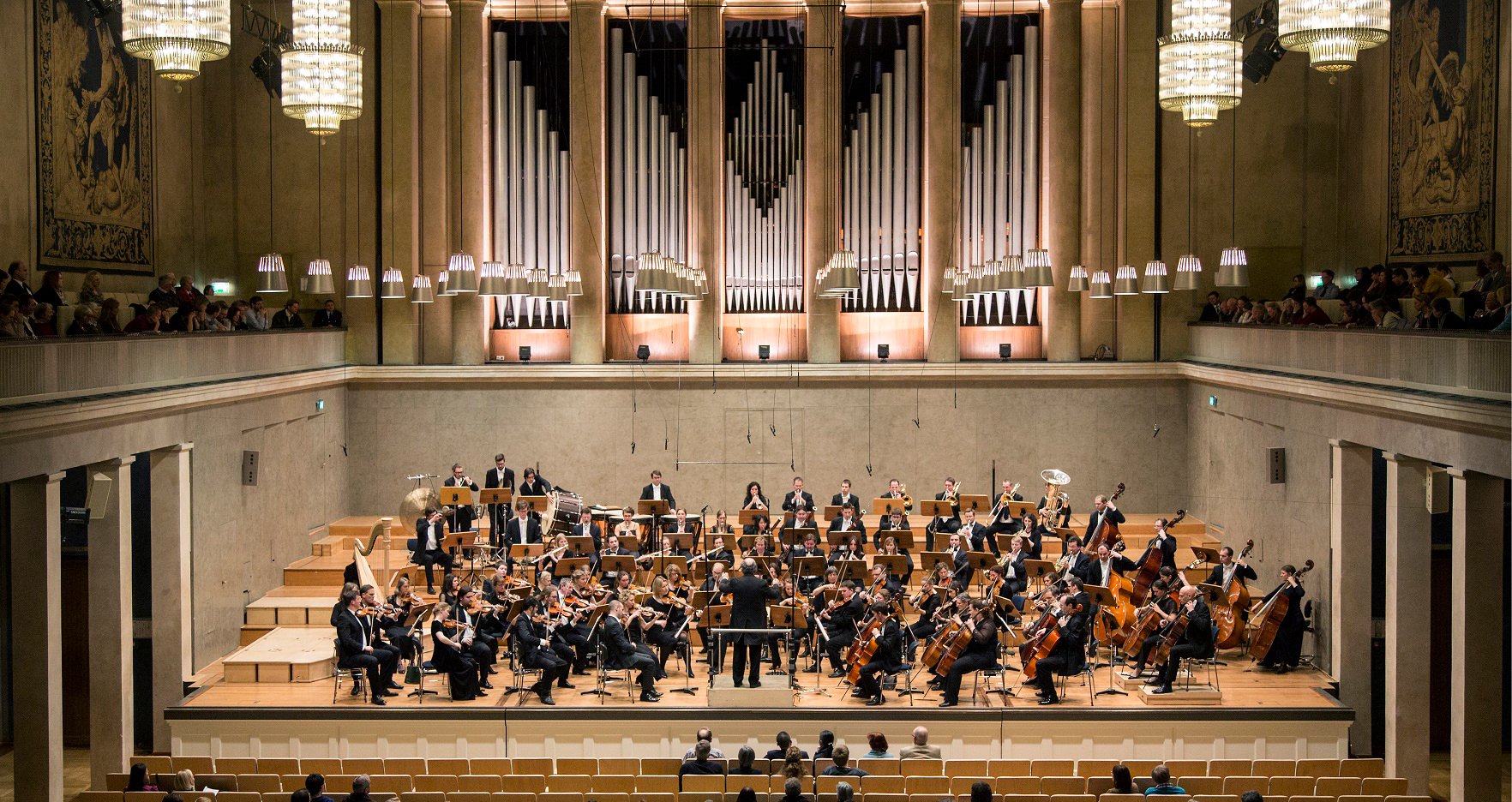 Orchester von oben fotografiert in einem großen Konzertsaal