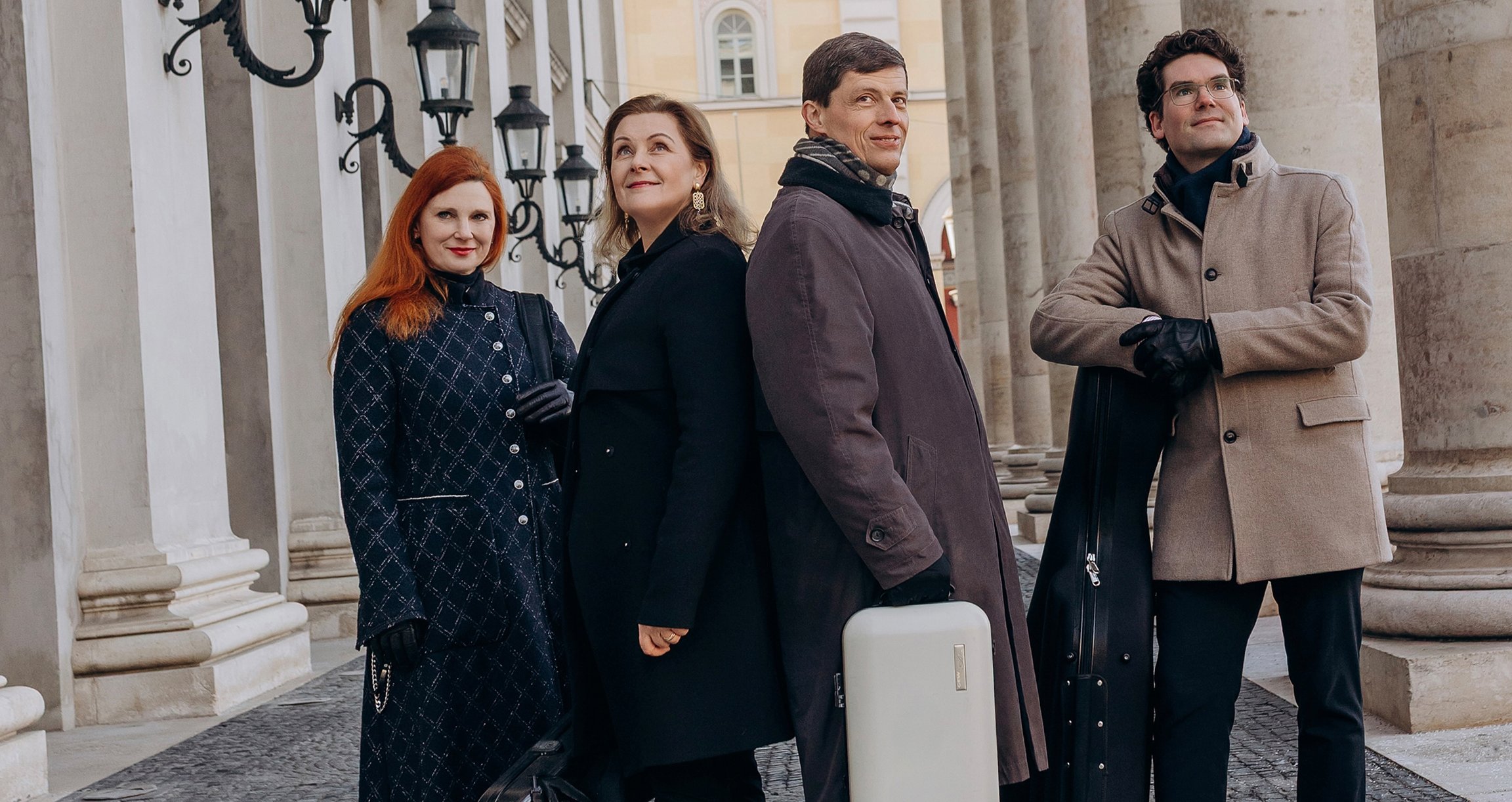 Henschel & FRIENDS stehen vor dem Bayerischen Nationaltheater und schauen in die Ferne