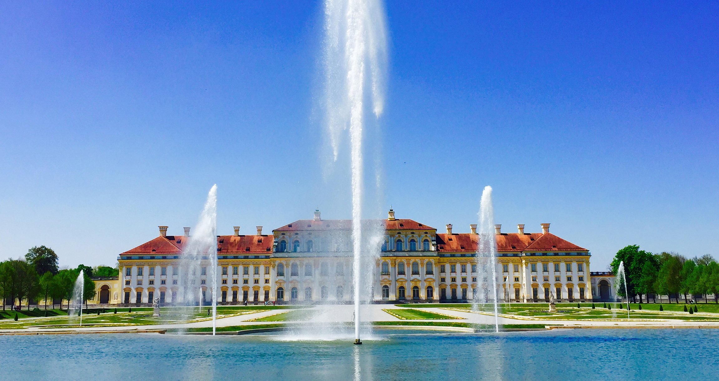 Schloss Schleißheim in seiner vollen Pracht mit großen Springbrunnen im Vordergrund