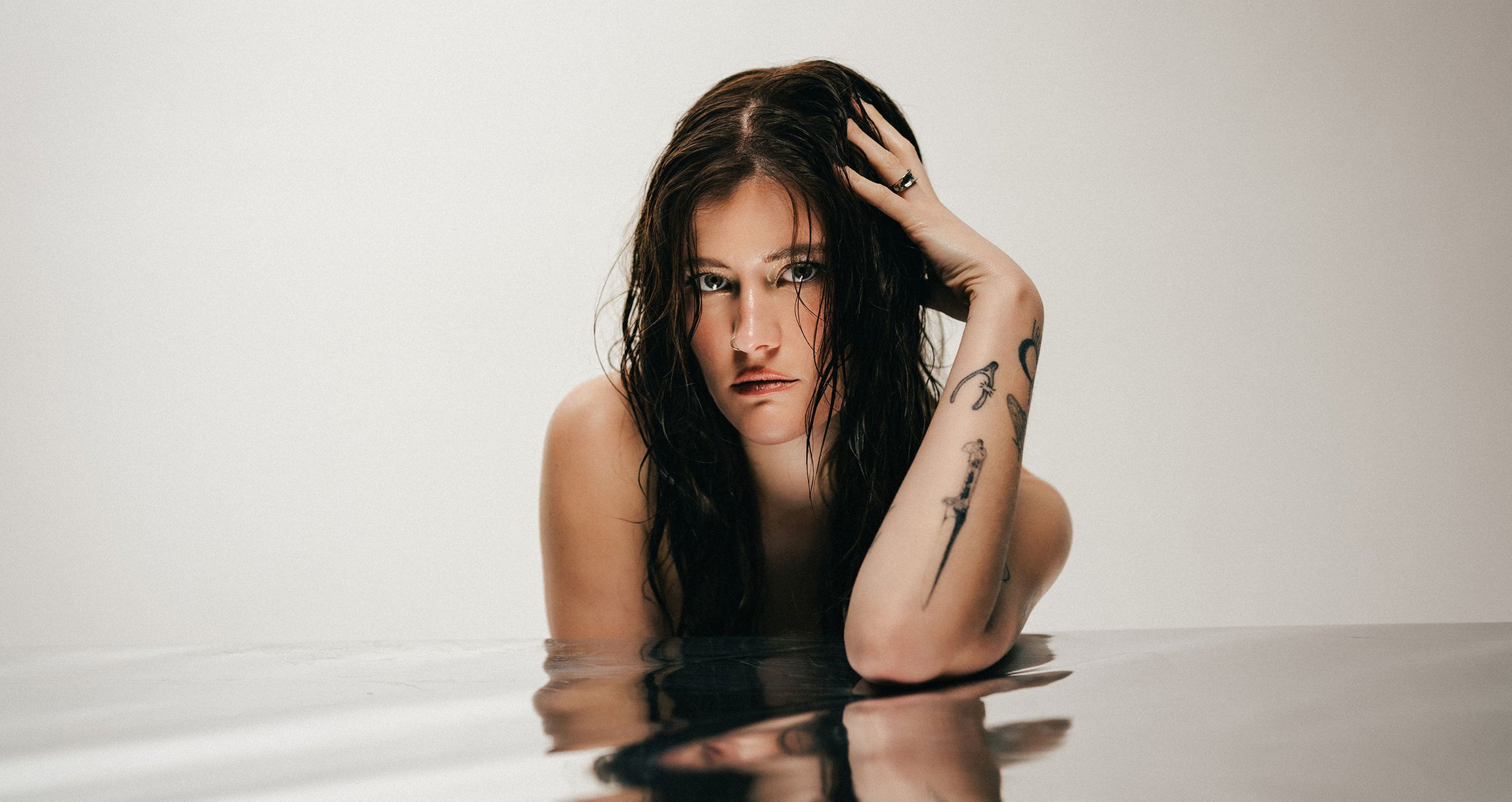 Madeline Juno mit nassen Haaren über einer Wasserspiegelung