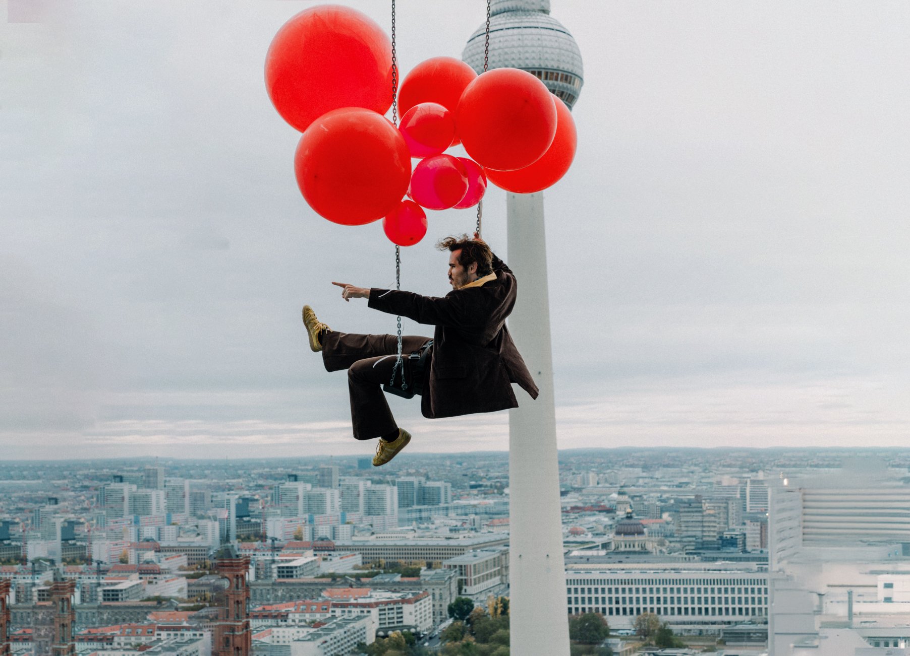 Der Sänger hängt an Luftballons und fliegt über Berlin