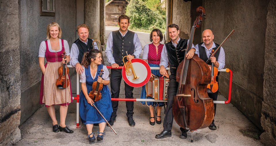 Ein Gruppenfoto einiger Musiker zusammen mit ihren Instrumenten.